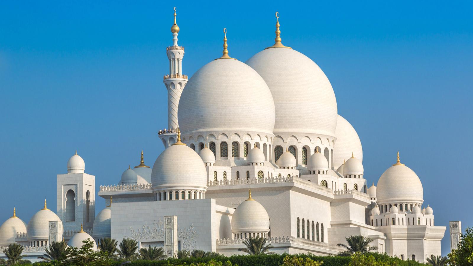 A close-up of the Sheikh Zayed Grand Mosque in Abu Dhabi against a clear blue sky.
