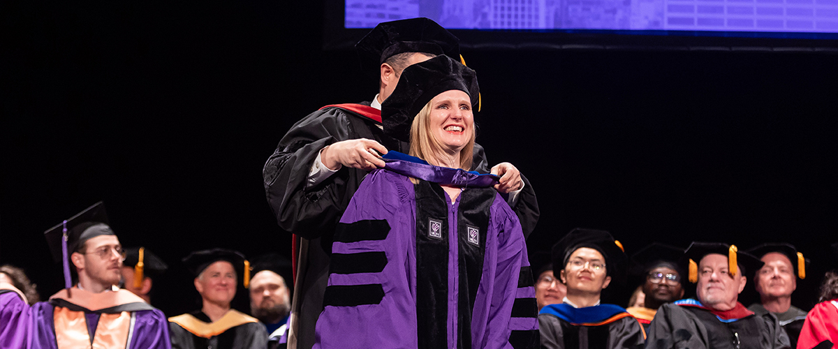 Kelley Akiya being hooded by Dr. José Pagán