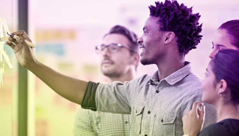 Group of professionals looking at a marker board